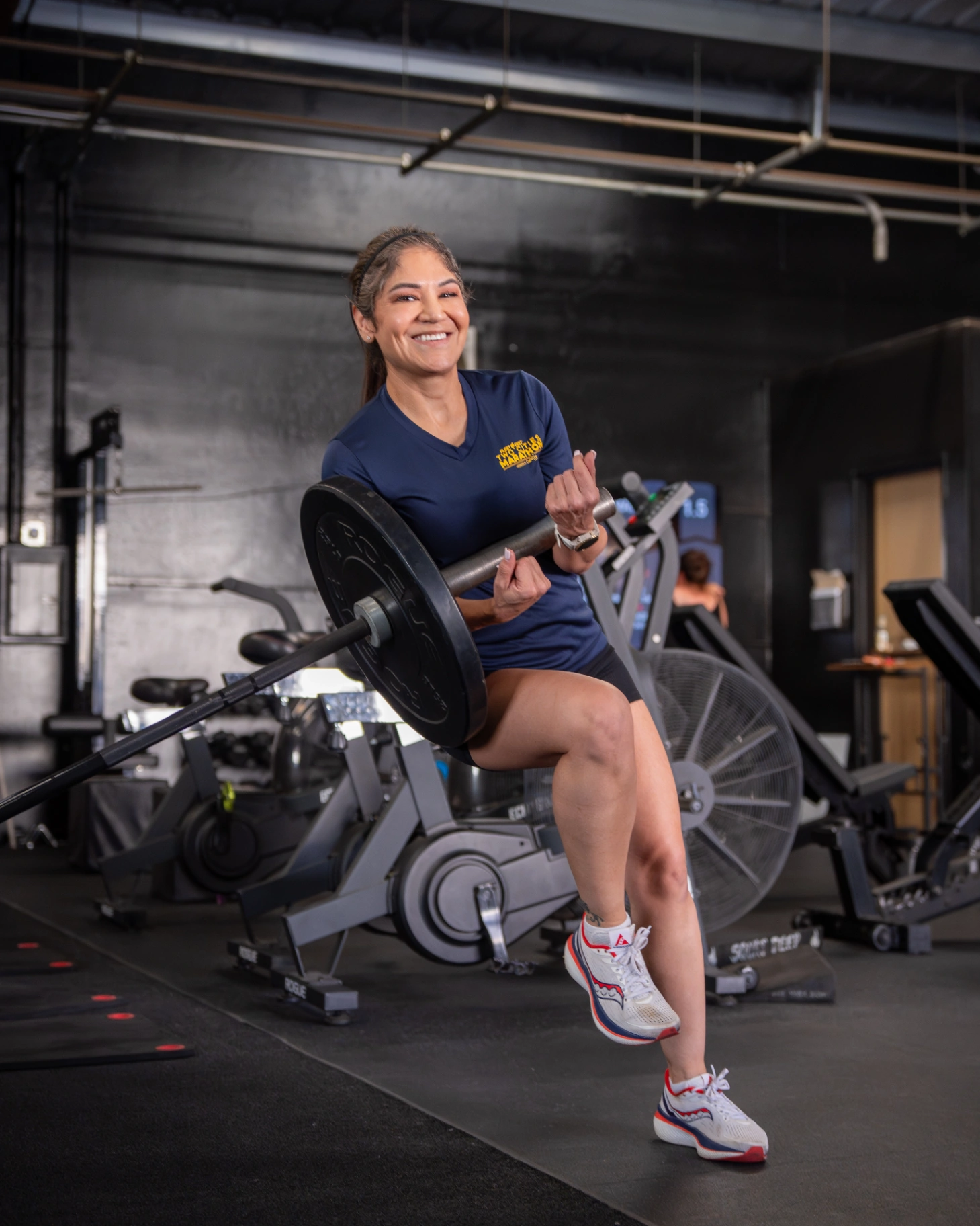 Grindhäus client performing a barbell curl